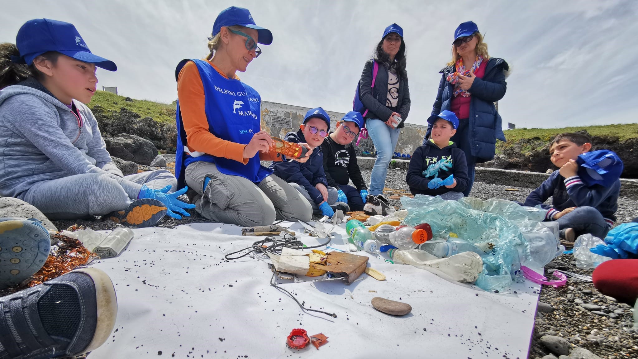 Operatori Marevivo che mostrano i diversi rifiuti raccolti in spiaggia a Ustica