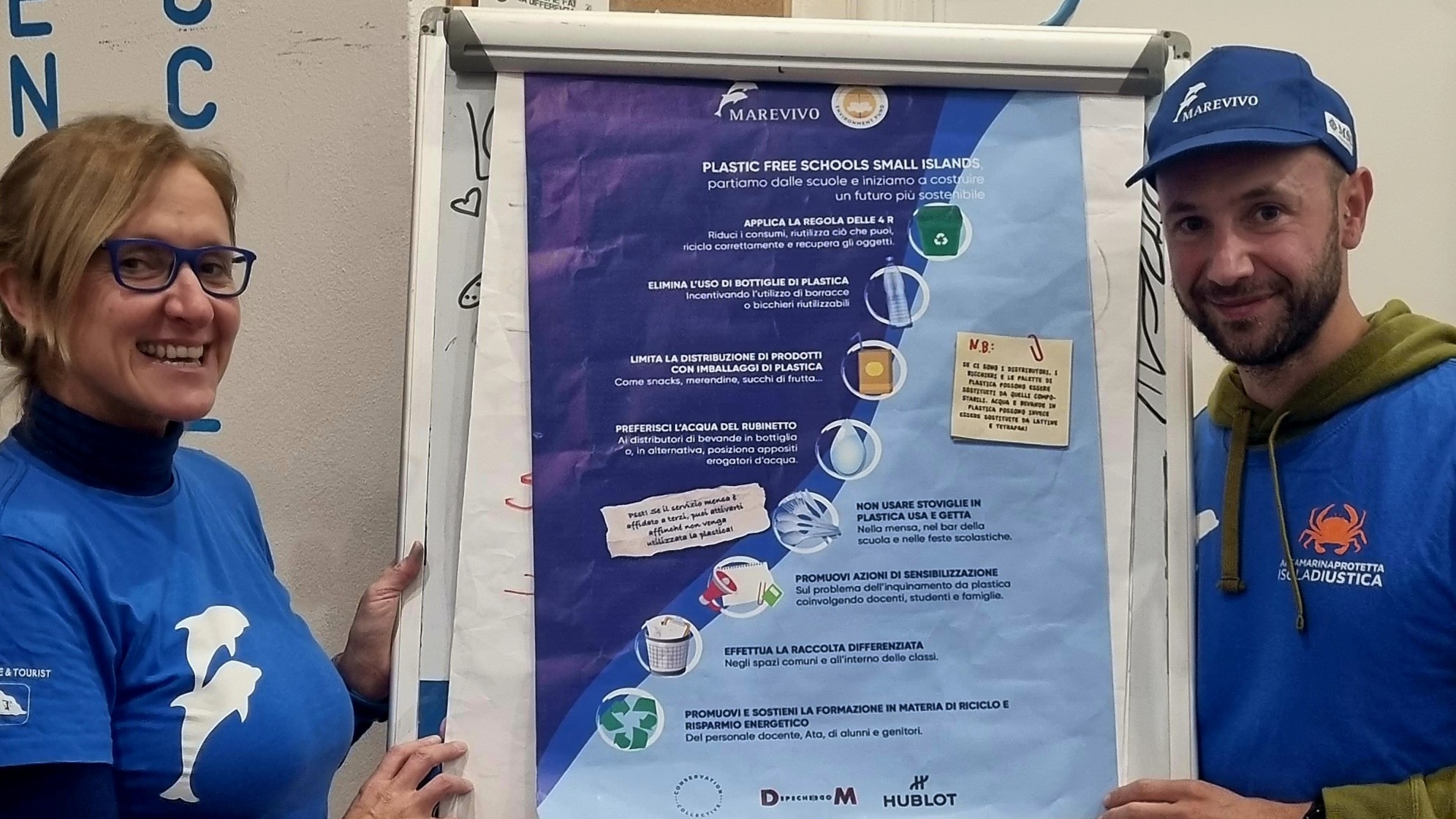 Operatori ambientali che mostrano il poster di Plastic Free schools small islands 